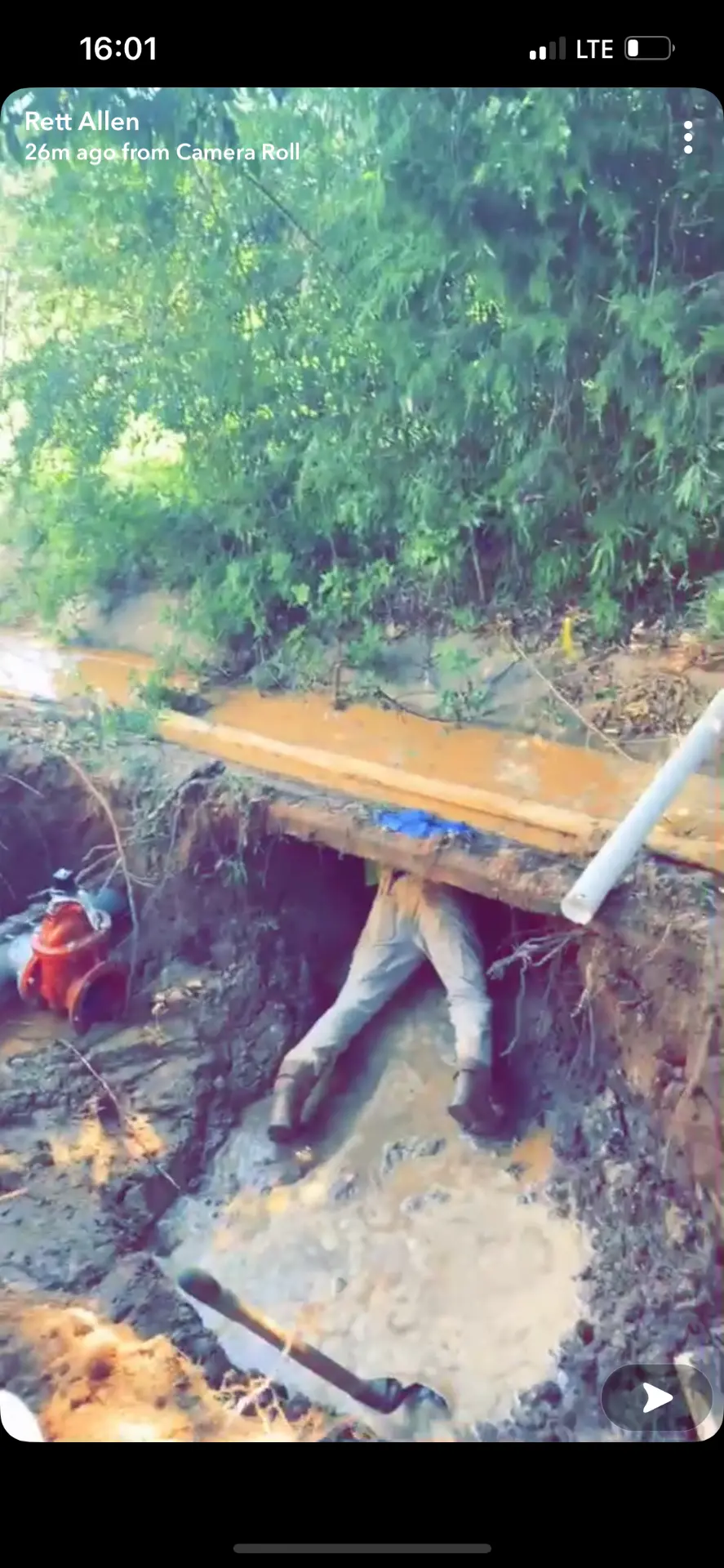 Littles Plumbing technician working inside an open trench on a buried water line