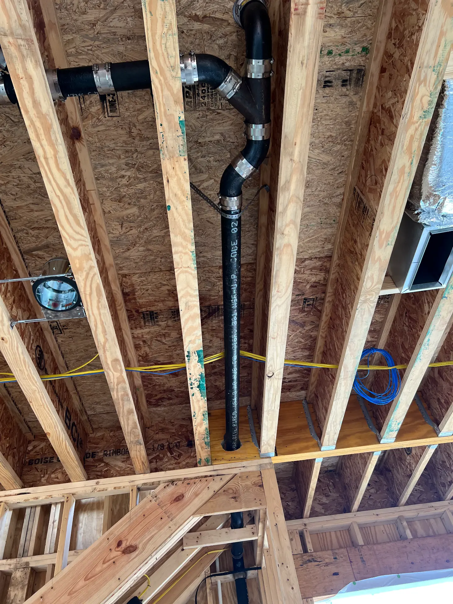 Cast iron drain and vent stack installed through floor joists on a new build