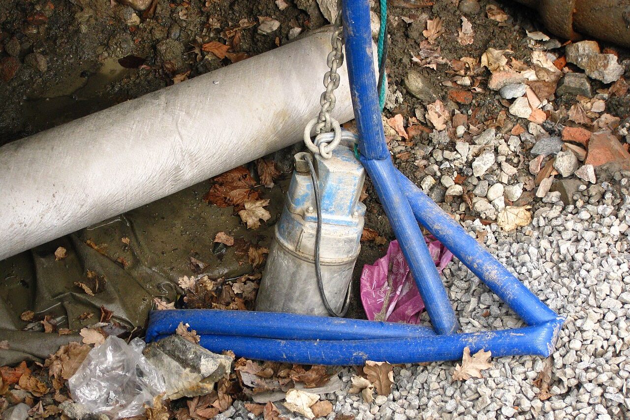 Submersible pump set in an excavated pit with discharge line connected